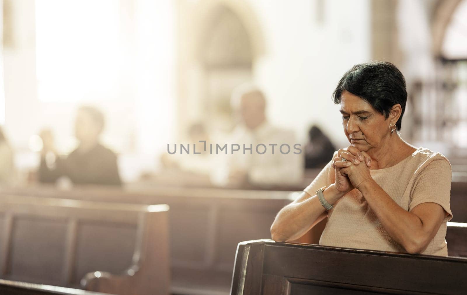 Senior woman praying in church, worship and trust God, prayer or spiritual respect. Christian woman praise in holy temple of religion, faith and sunday congregation for bible service, peace and grace by YuriArcurs