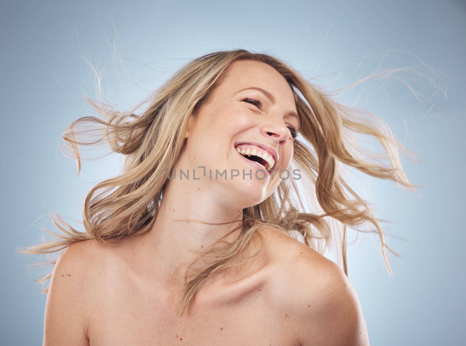 Face, beauty and hair care of woman in studio isolated on a gray background. Keratin, cosmetics or female model happy with curly hairstyle after salon treatment for growth, blonde balayage or texture.