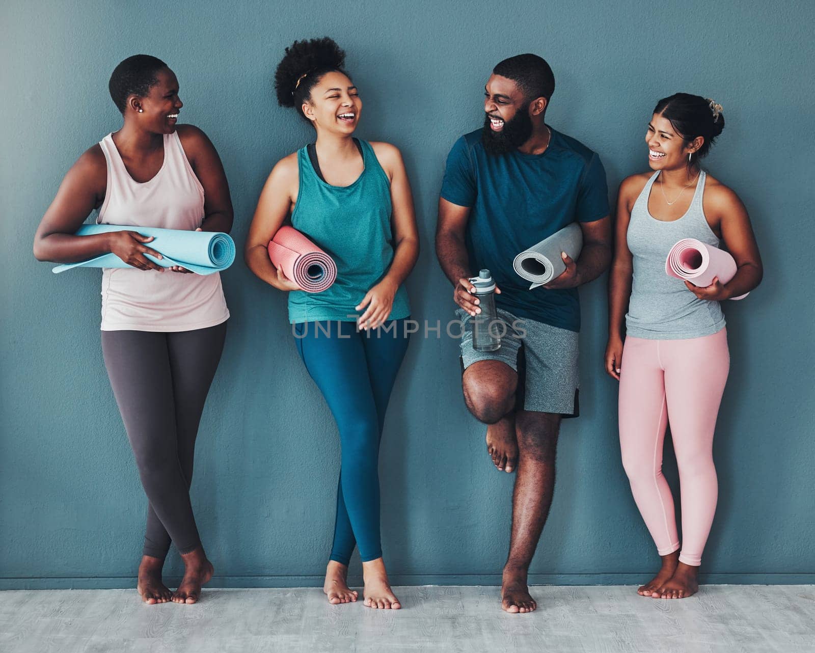Yoga, fitness friends and wall of pilates class in a gym with a exercise and training break. Talking, wellness black people and communication of group on a floor ready for zen, balance and relax by YuriArcurs