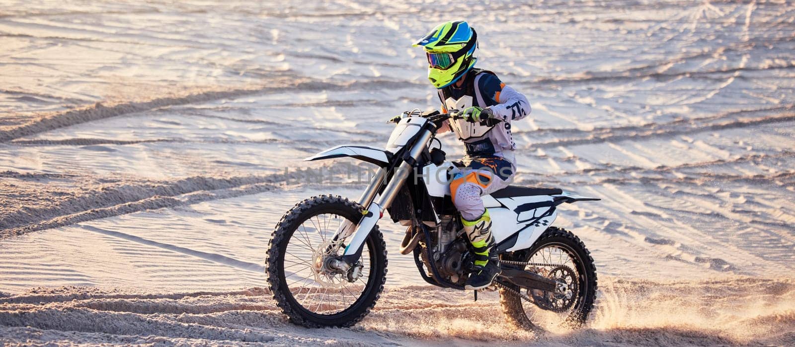 Motorcycle, desert race and extreme sport expert with agile speed, power or balance in nature. Motorbike man, rally and sand on fast vehicle with helmet, safety clothes and motivation for motorsport.