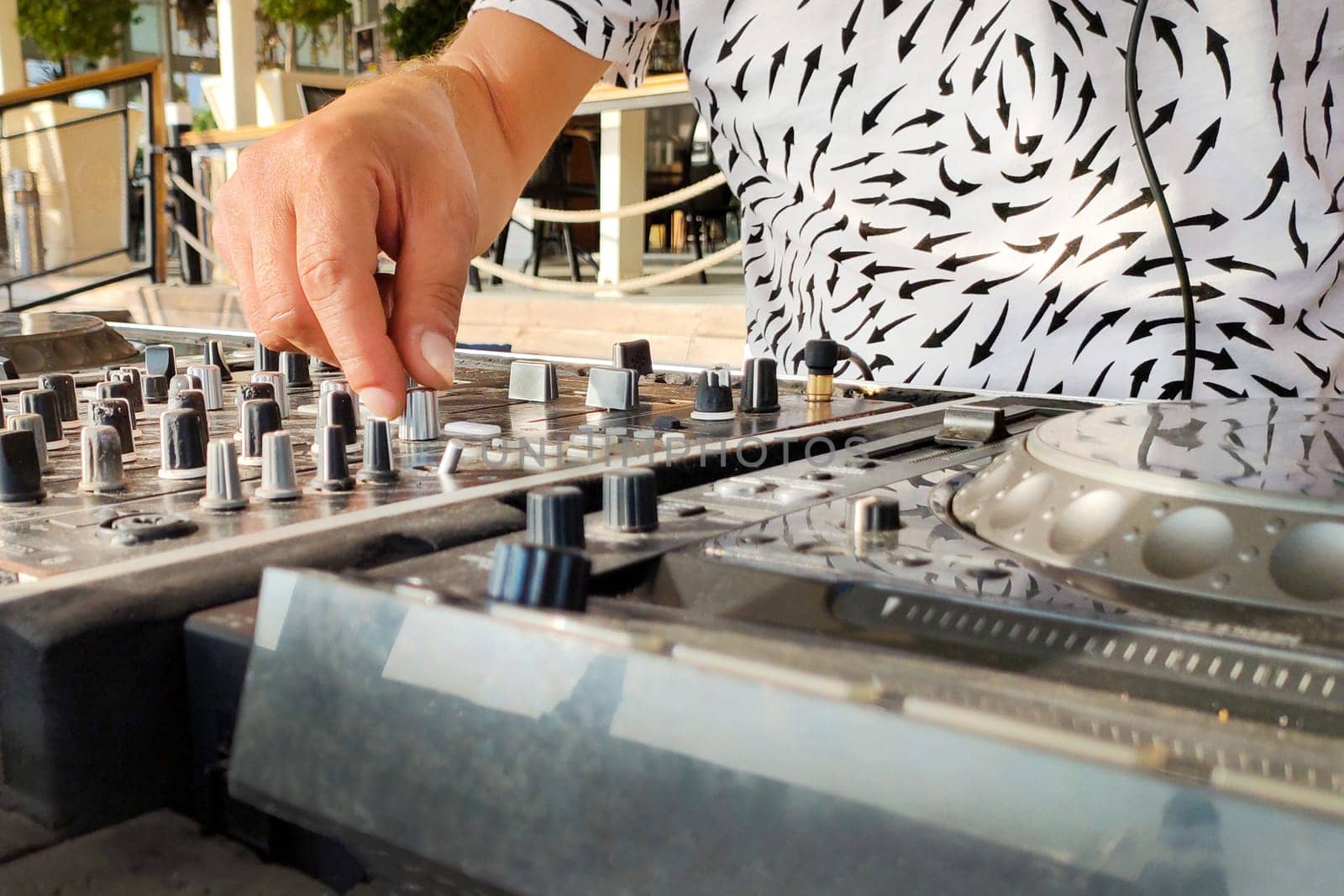 Turkey, Alanya - August 12, 2022: DJ creates music on mixing player, hands and mixer close-up