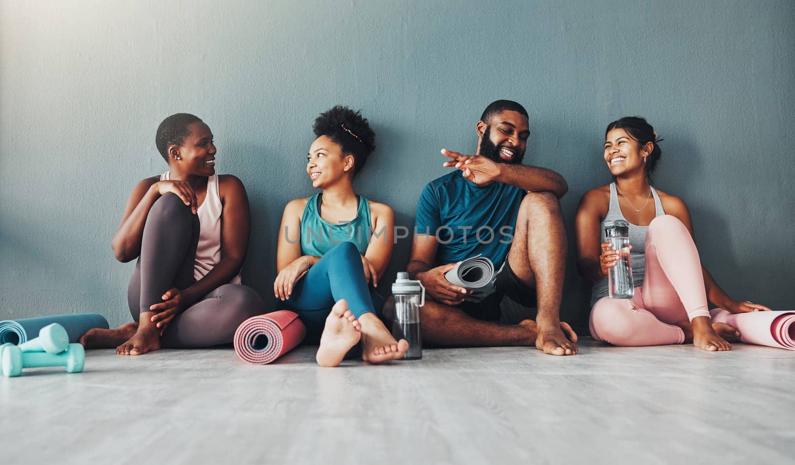 Yoga, fitness group and diversity of pilates class in a gym with a exercise and training break. Talking, wellness people and communication of friends on a floor ready for zen, balance and relax by YuriArcurs