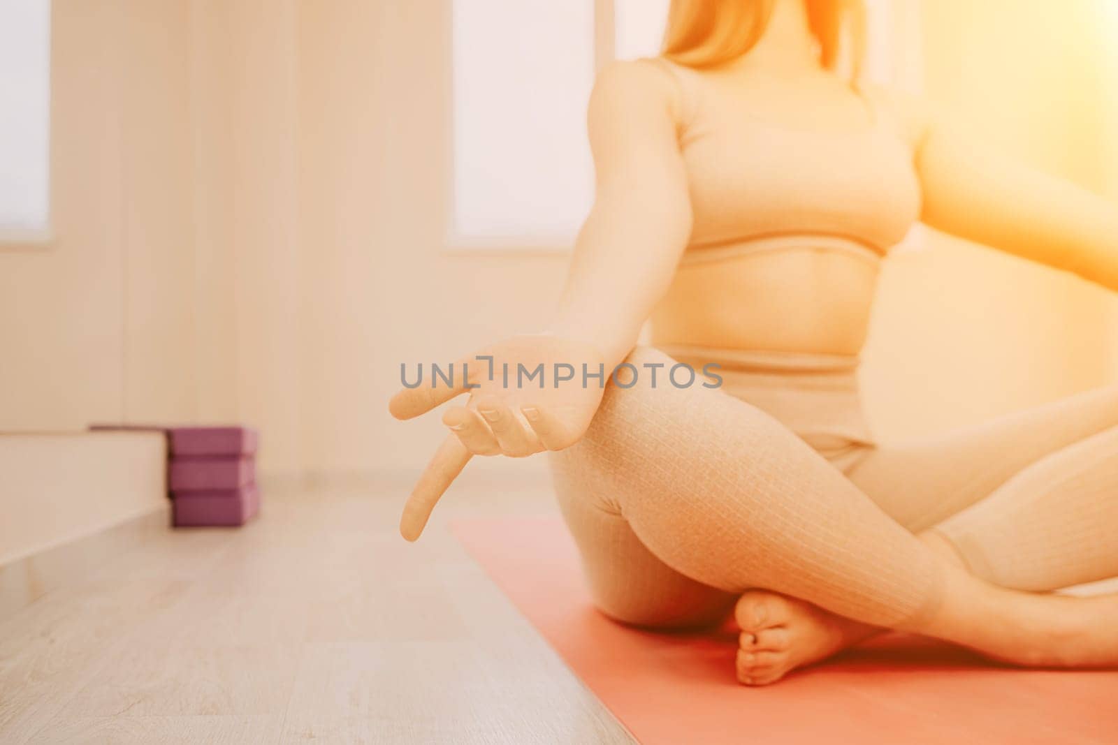 Group of young womans fitness instructor in Sportswear Leggings and Tops, stretching in the gym before pilates, on a yoga mat near the large window on a sunny day, female fitness yoga routine concept.