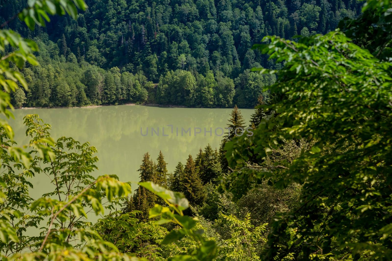 View on the turquoise color lake between high and rocky mountains. Beautiful alpine landscape.