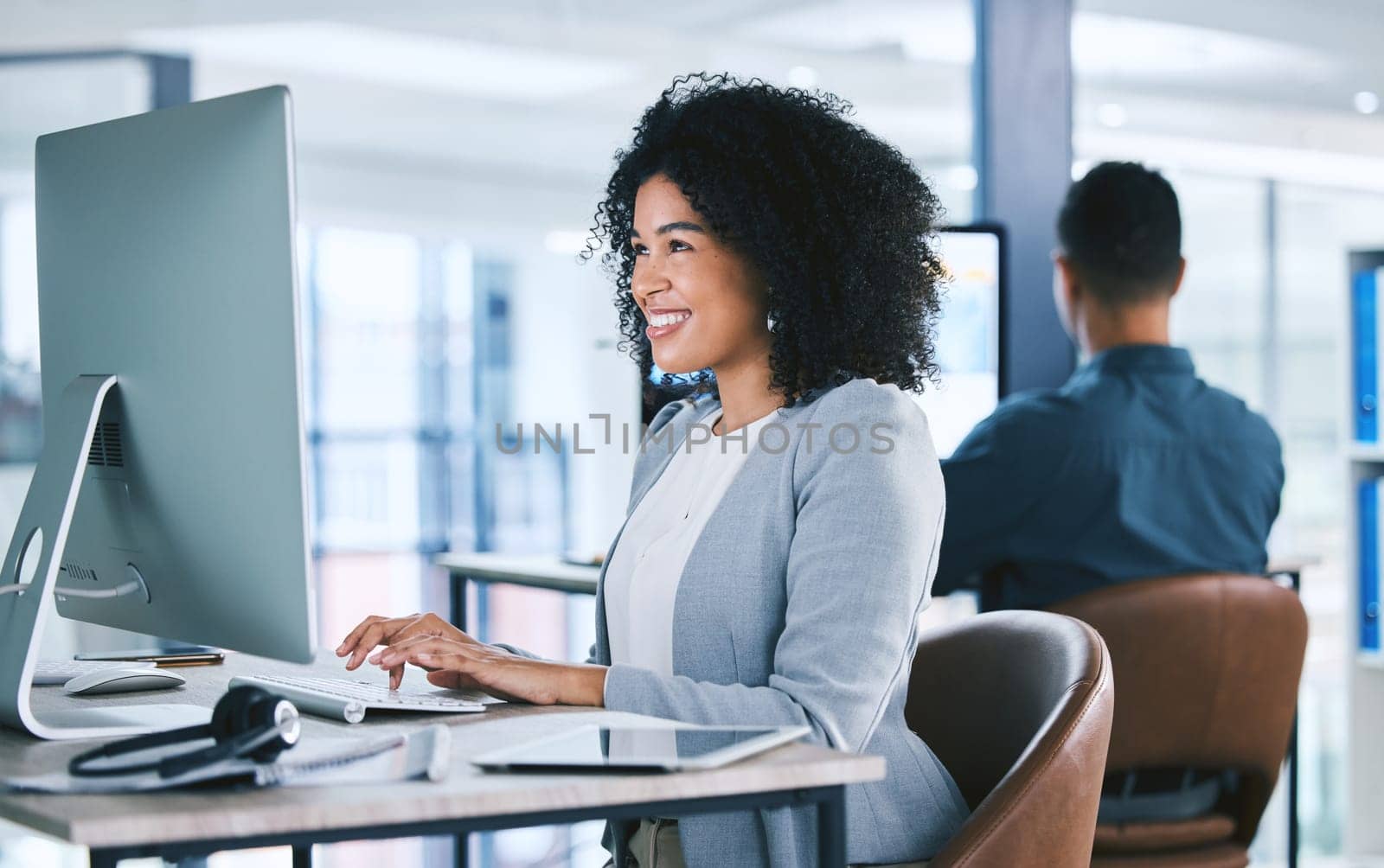 Woman, typing at computer with online tech support and email, consultant at desk with smile at customer service agency. Contact center, communication and happy female agent with feedback and help.