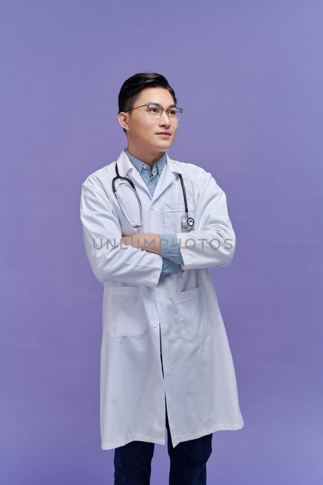 Portrait of confident positive smiling asian male doctor wearing medical white uniform coat and stethoscope