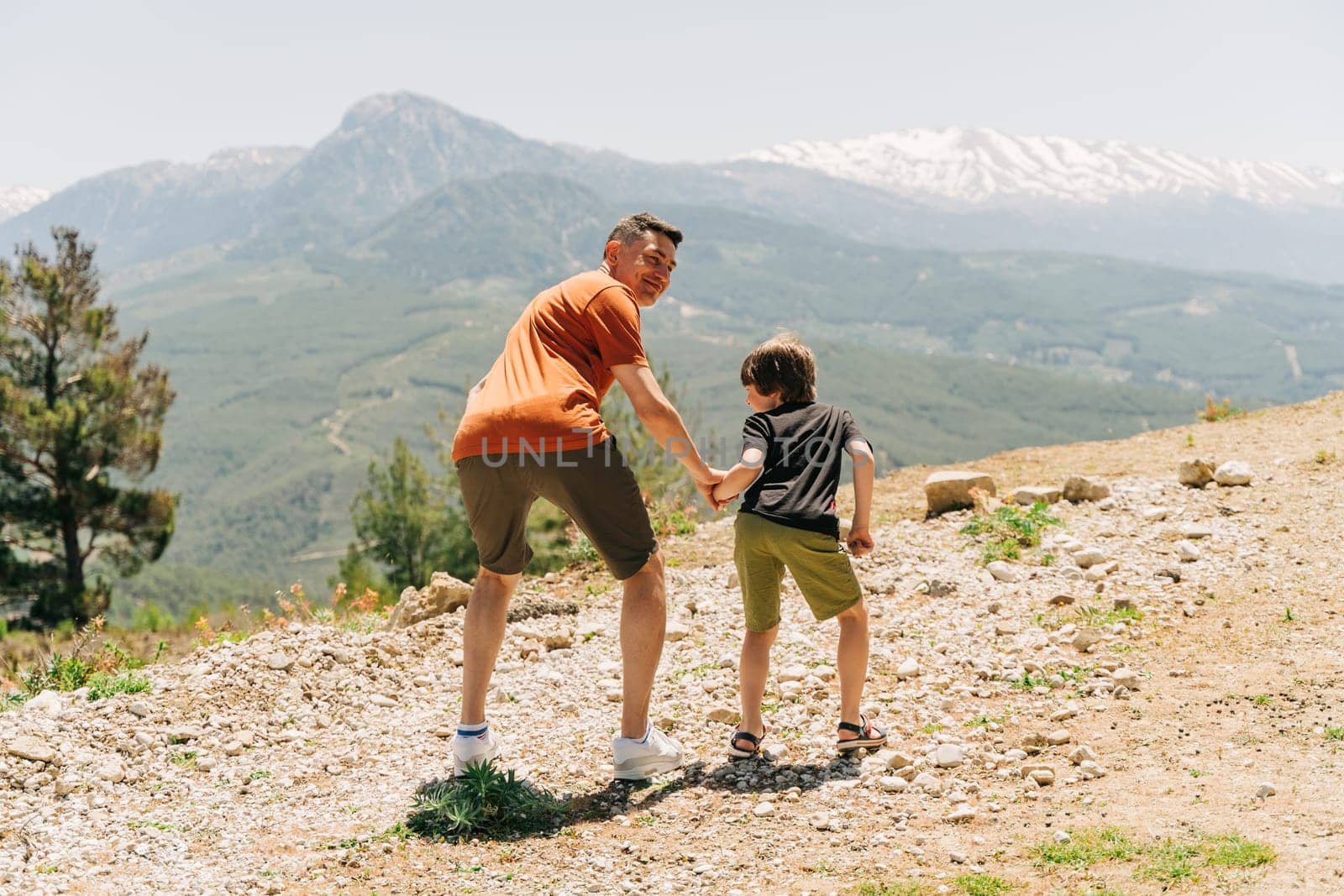Young dad and his son standing on Mountain View. Child kid boy having fun with father on mountains hiking.