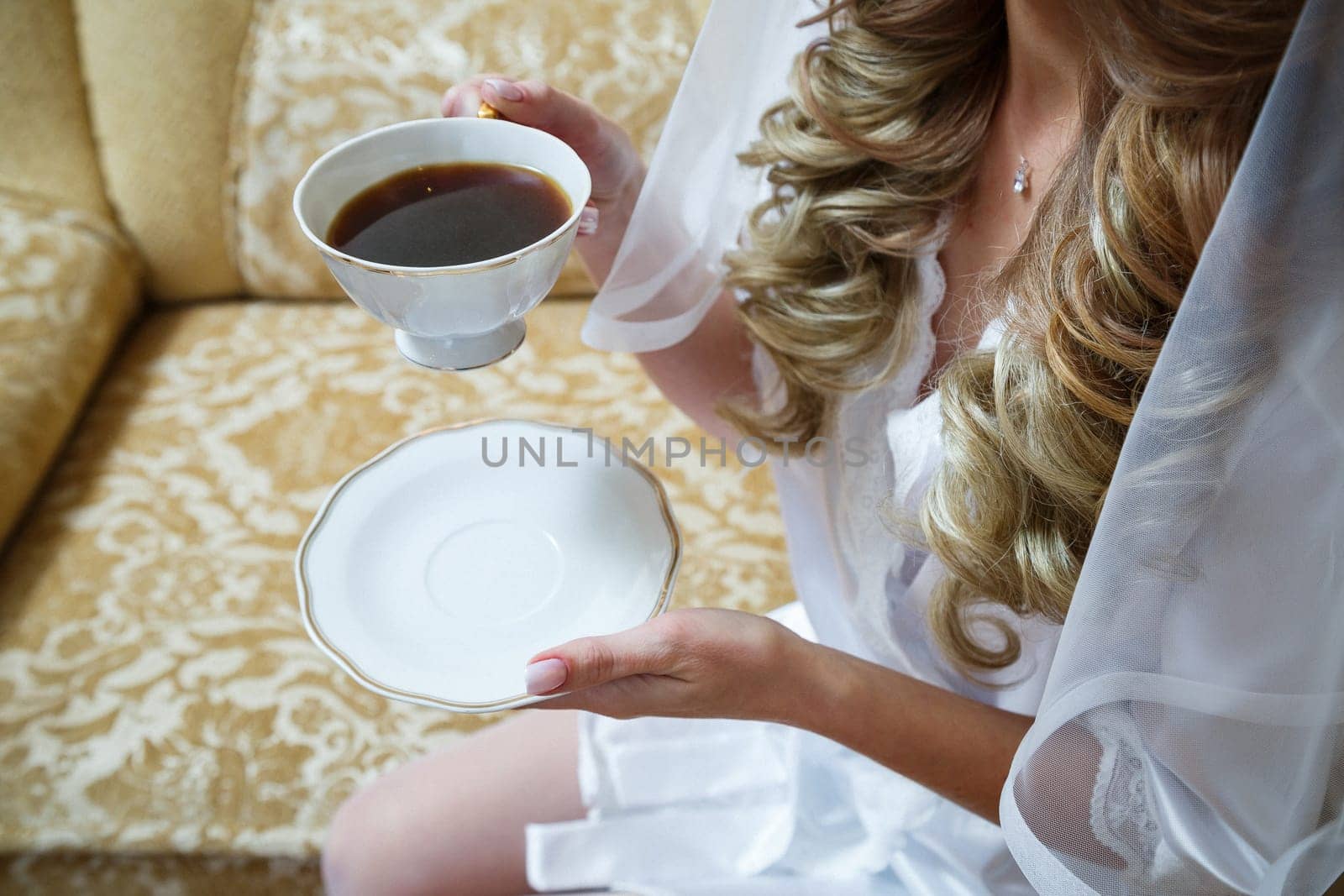 Girl bride drinks coffee on wedding morning