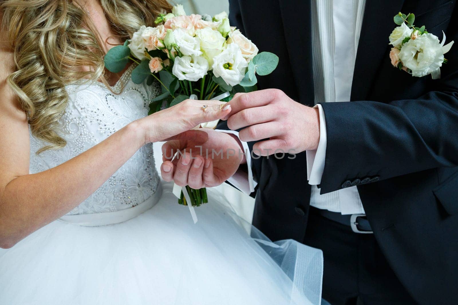 gold wedding rings in hands of newlyweds on wedding day