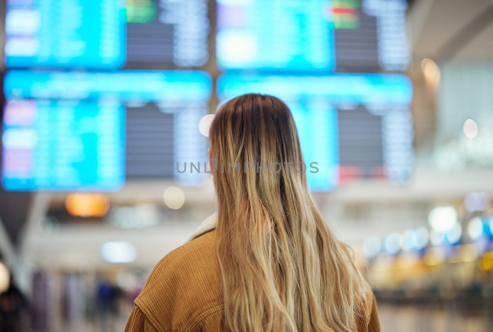 Woman, airport and reading board, screen and flight schedule for travel, plane and adventure with back. Girl, immigration and global transportation in lobby for airplane time, departure or arrival.
