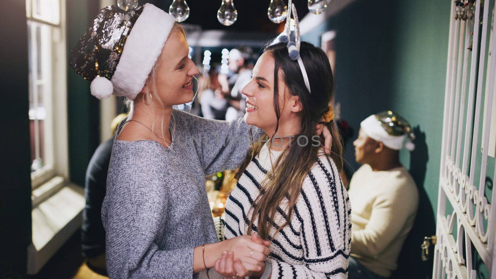 Lesbian couple, dance and Christmas party in home or festive celebration. Event, love and romance of women dancing face to face, holding hands and celebrating holiday together in house with friends
