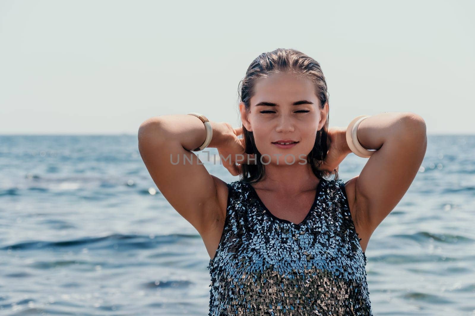 Woman summer travel sea. Happy tourist enjoy taking picture outdoors for memories. Woman traveler posing on the beach at sea surrounded by volcanic mountains, sharing travel adventure journey by panophotograph