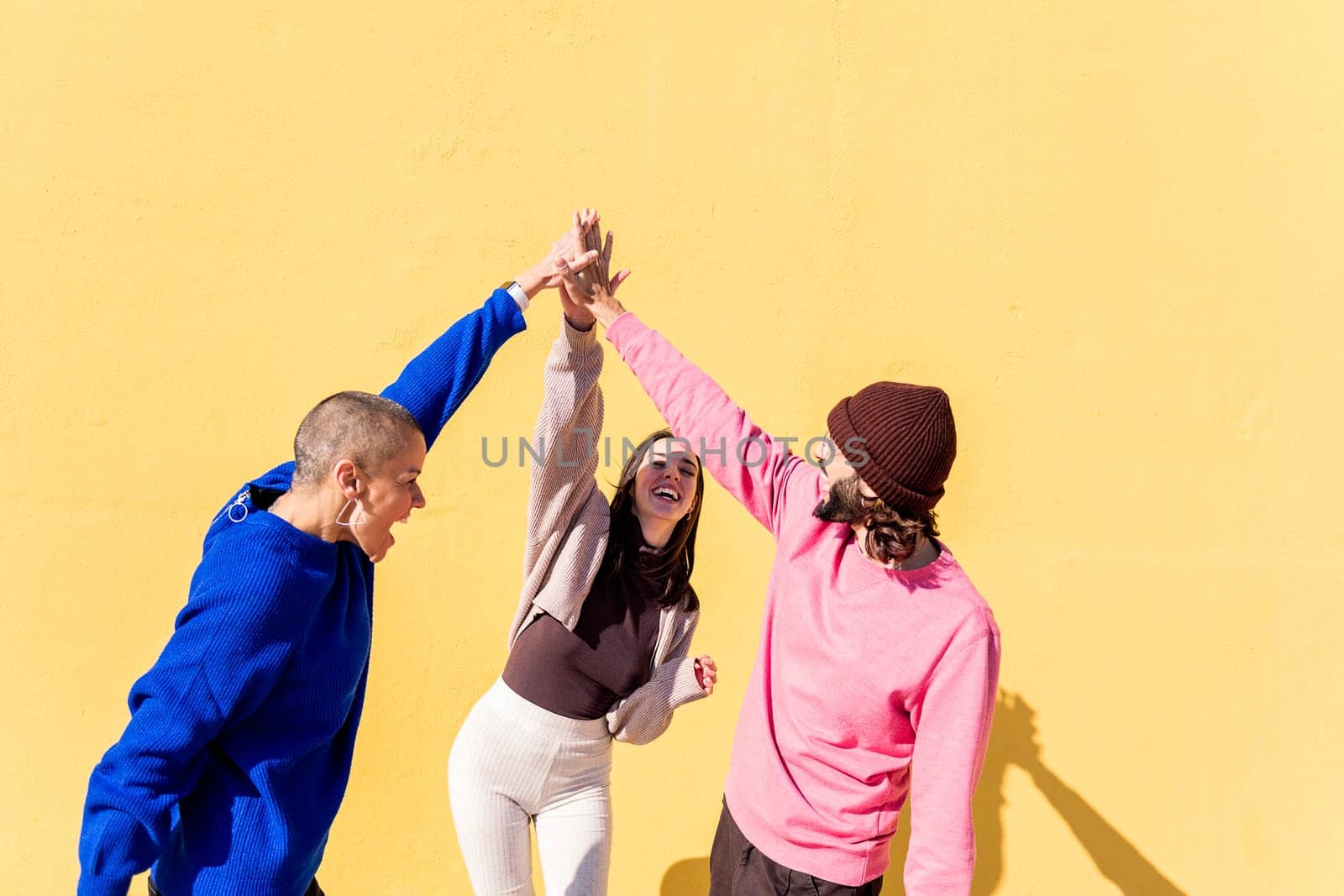 joyful young people high fives and having fun by raulmelldo