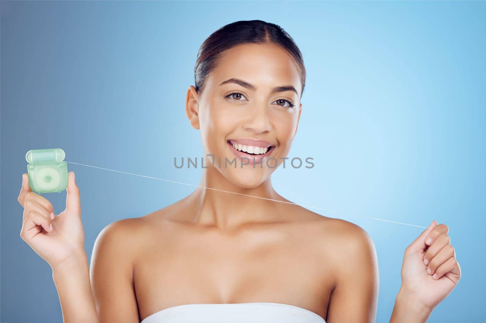 Floss product, dental portrait and woman on studio mockup for teeth, mouth cleaning and marketing. Happy female model, flossing thread and blue background for tooth cosmetics, wellness and healthcare.