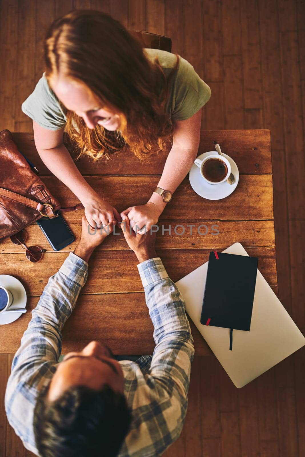 Above, couple and coffee shop with holding hands, love and conversation for romance at table. Man, woman and valentines date in cafe for support, bonding and talking with happiness, care and trust.