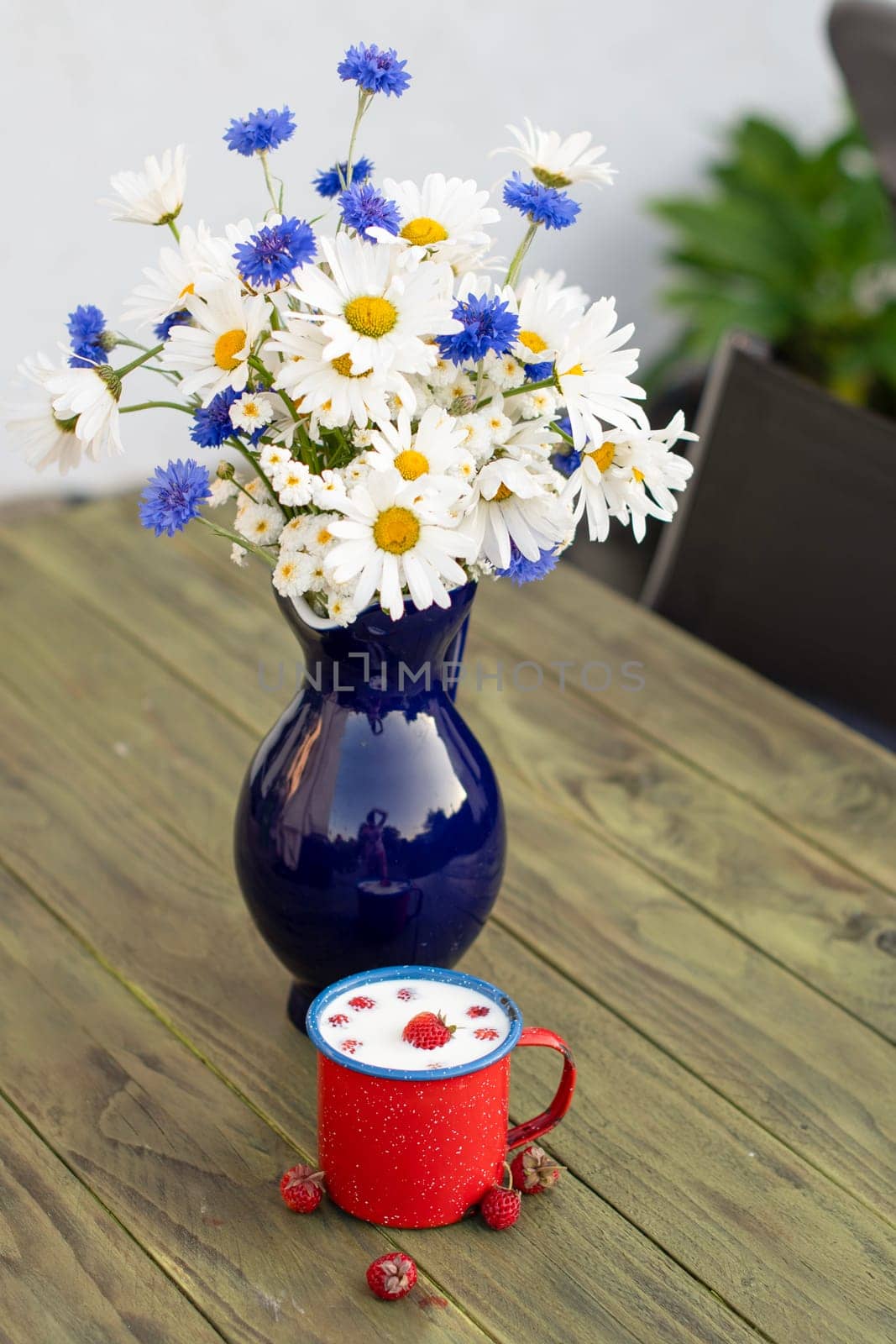 Fresh Strawberry with cold milk in red mug on wild flowers background,childhood nostalgia Healthy fruit dessert, food and drink, High quality photo