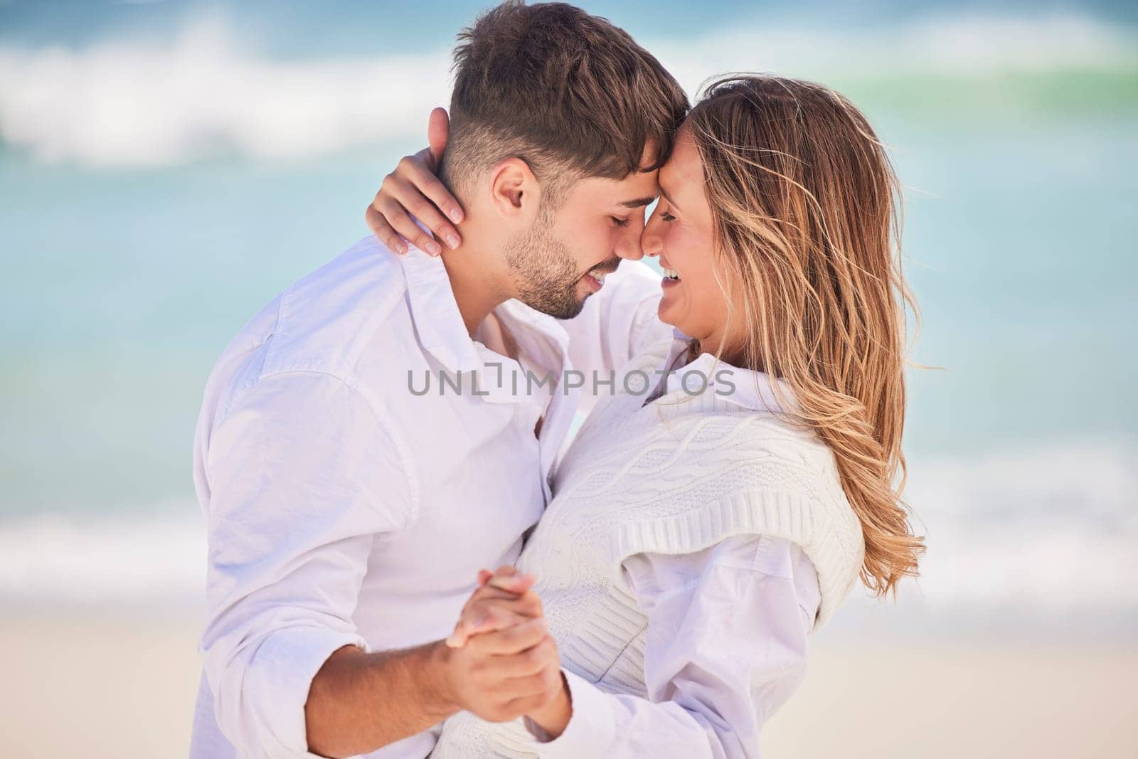 Love, dance and happy with couple on beach for date, romance and anniversary celebration. Smile, bonding and affectionate with man and woman on holiday for hug, vacation and happiness together by YuriArcurs