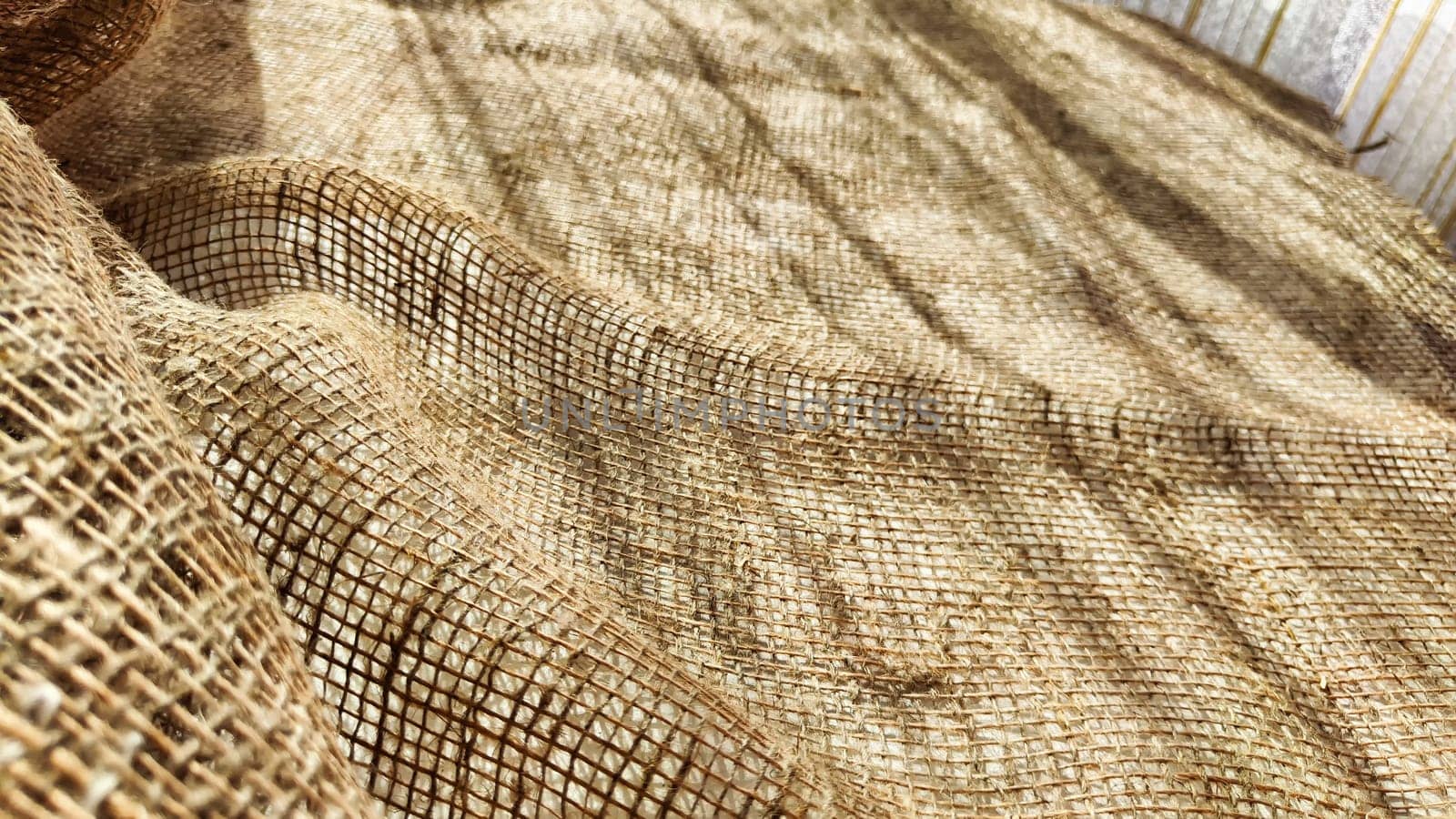 Natural fabric texture, frame and background of burlap. Rough crumpled burlap background. Selective and partial focus by keleny