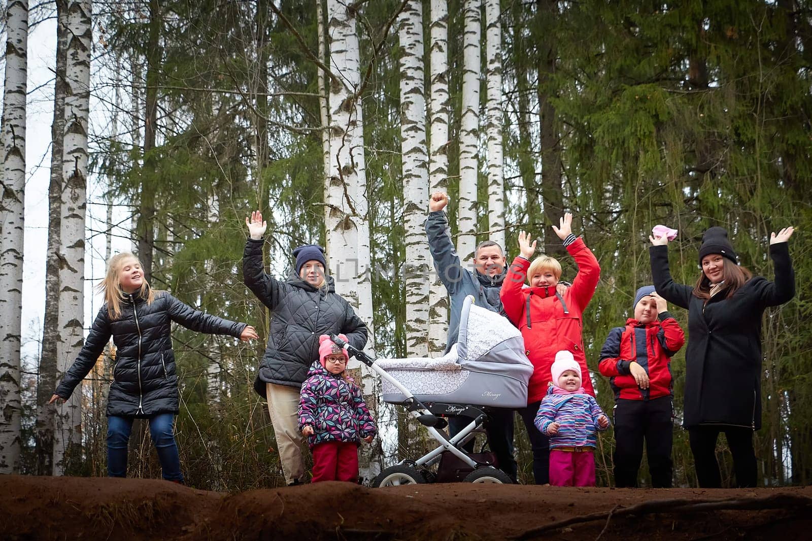 Kirov, Russia - October 23, 2022: Big family with parents, mom and dad, with children, toddlers, teenagers walking in park on an autumn day with yellow trees and leaves