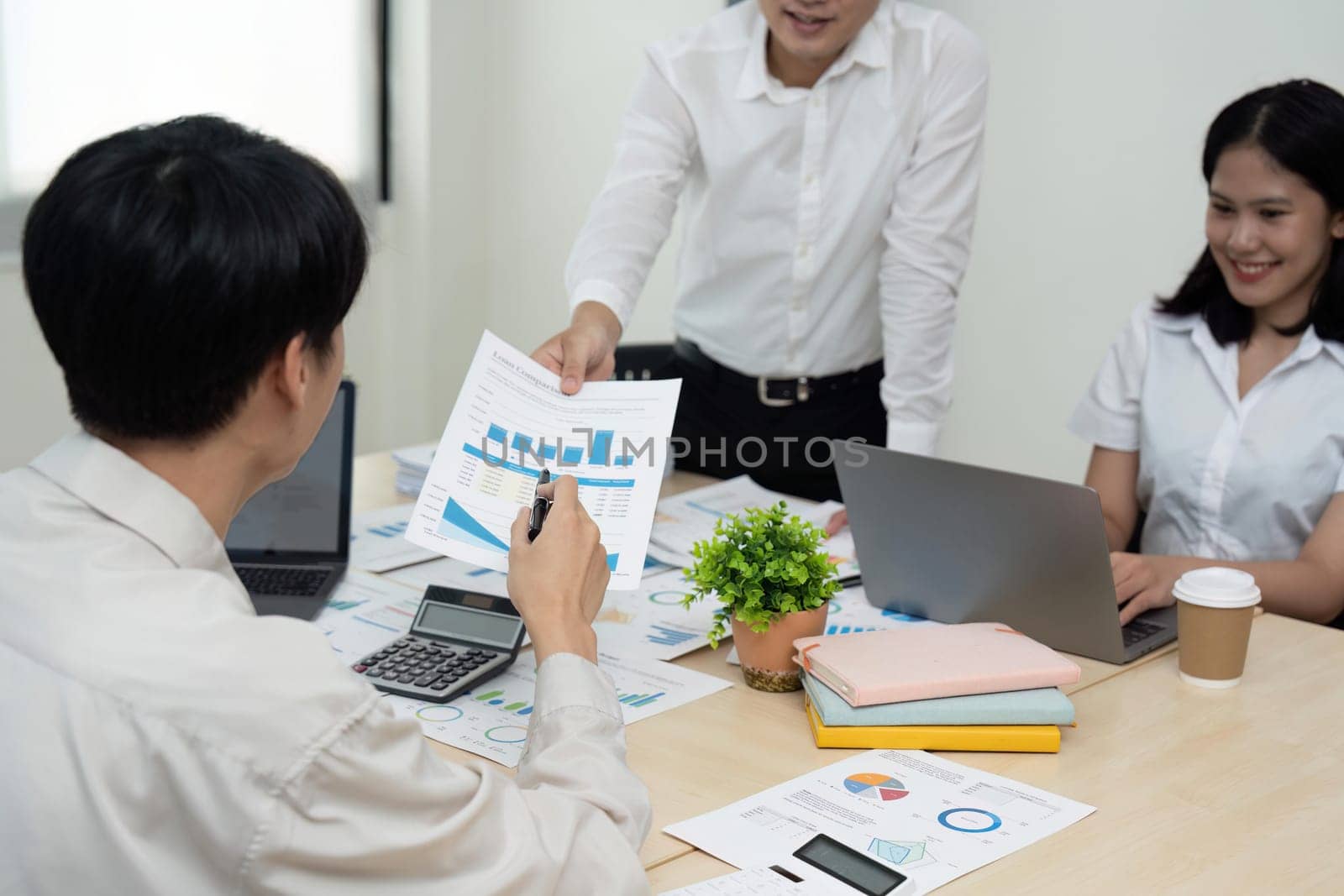 Business team people discussing analyzing investment charts the charts and graphs showing the results of their successful teamwork, typing keyboard, analyze graph plans.