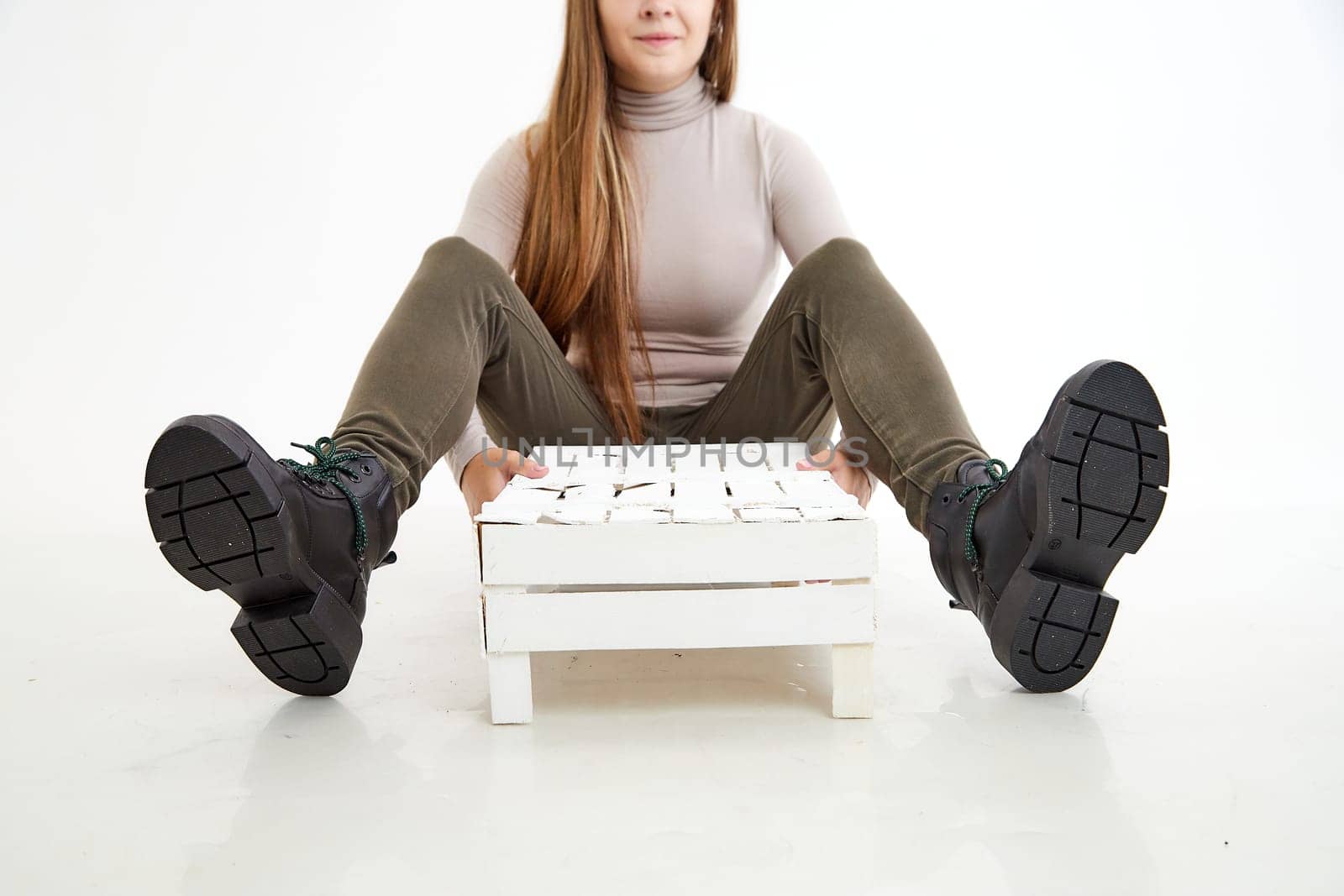 Female winter, autumn or spring black leather shoes on leg of woman in studio on white background. Fashionable modern photography and photoshoot for store, catalog, magazine or online