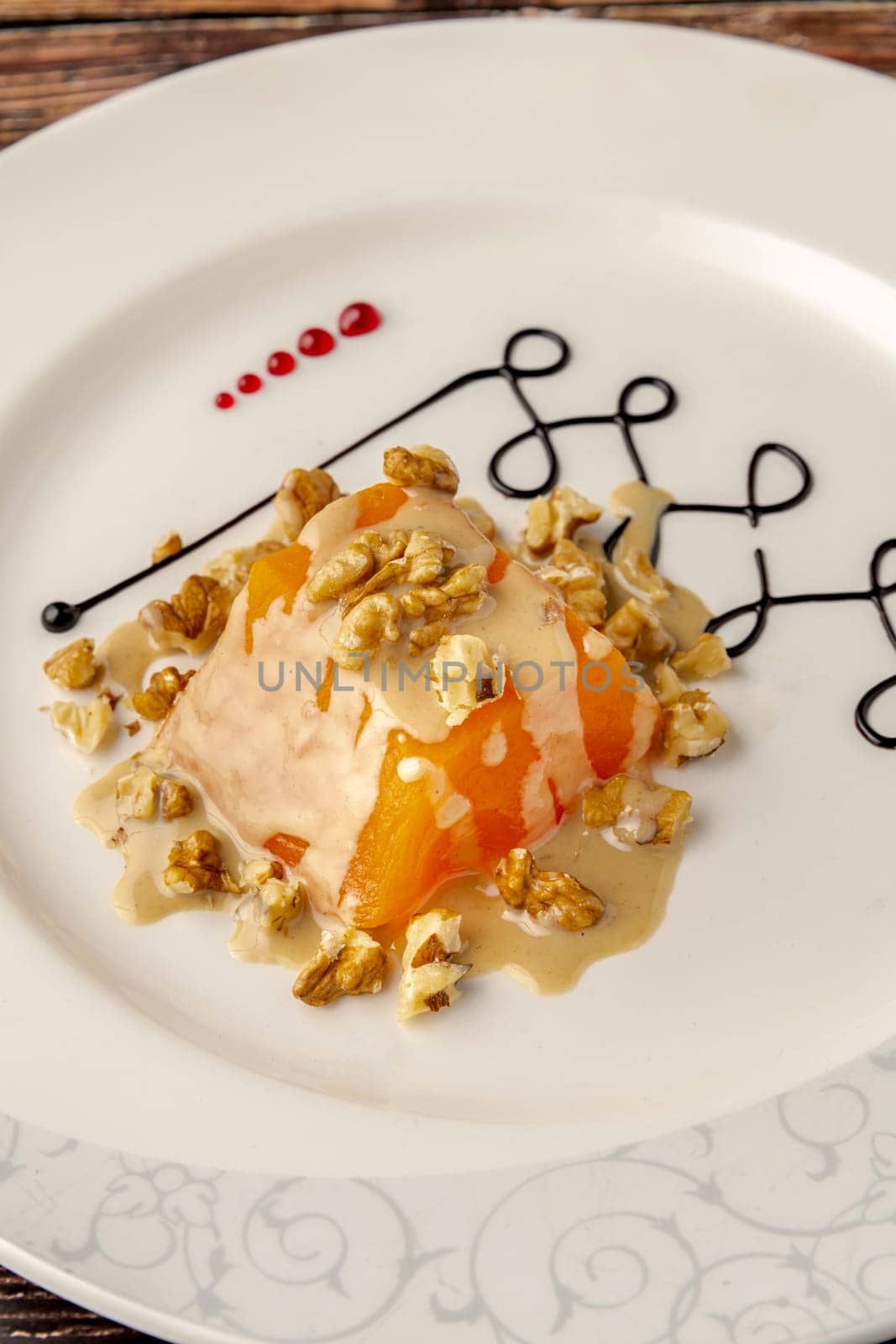 Pumpkin dessert with tahini and walnuts on a white porcelain plate