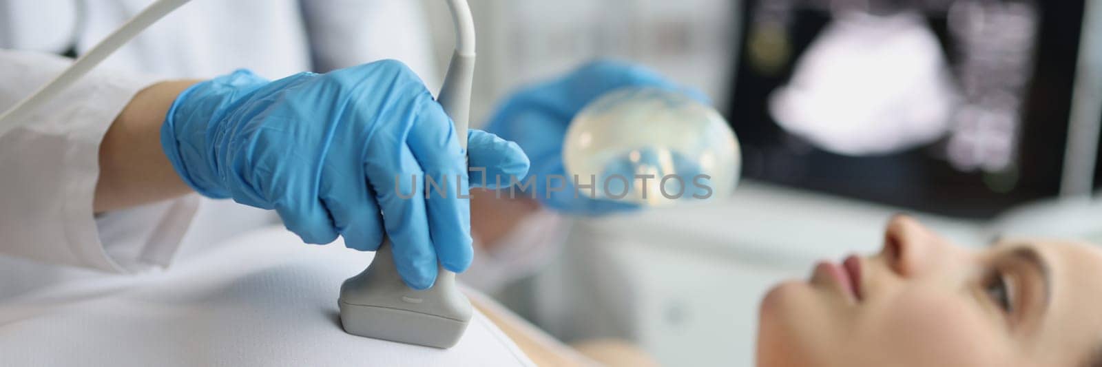 Female doctor examines woman breasts using ultrasound machine by kuprevich