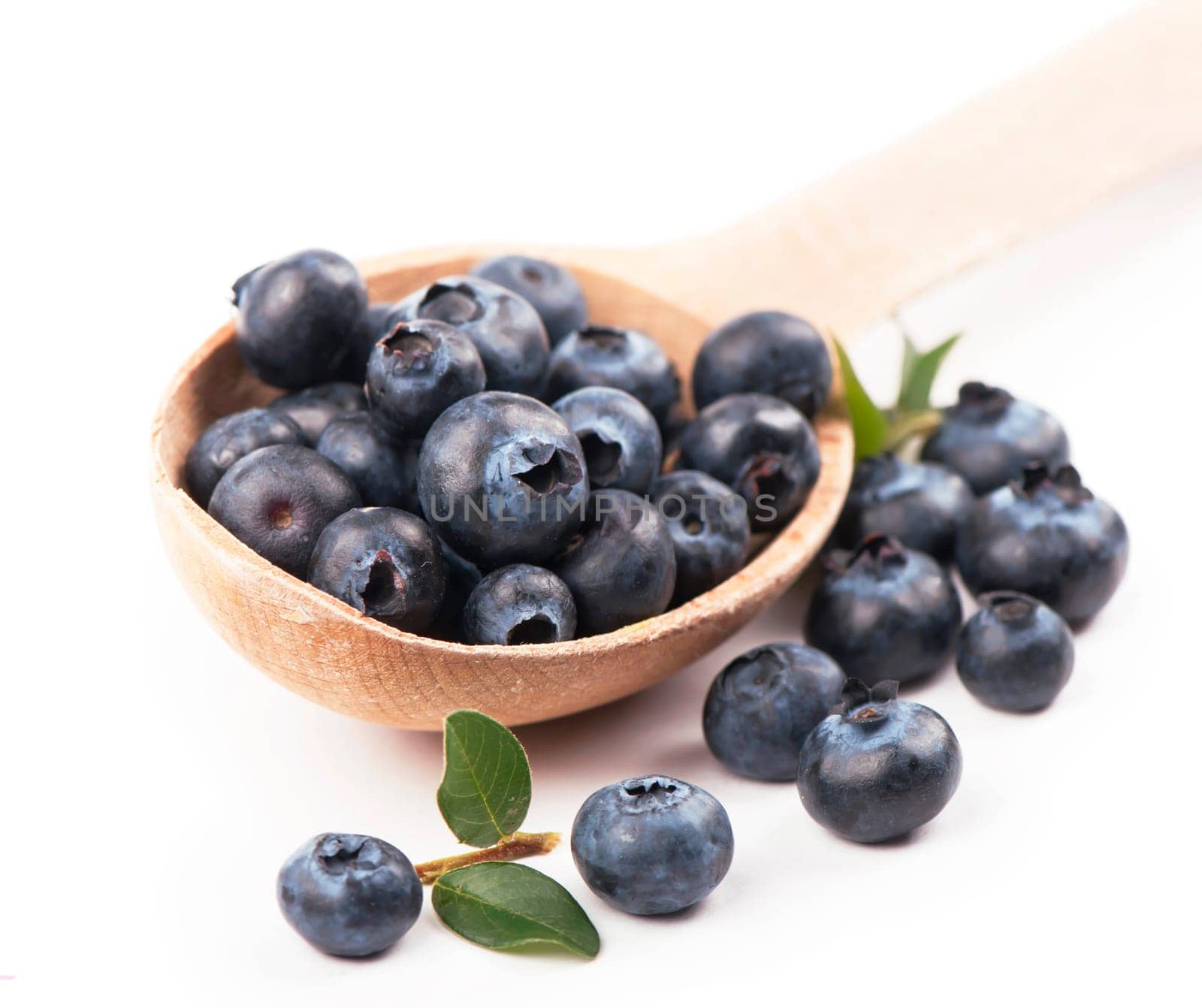 Fresh raw organic blueberries on wooden spoon on white background. Food concept. by aprilphoto