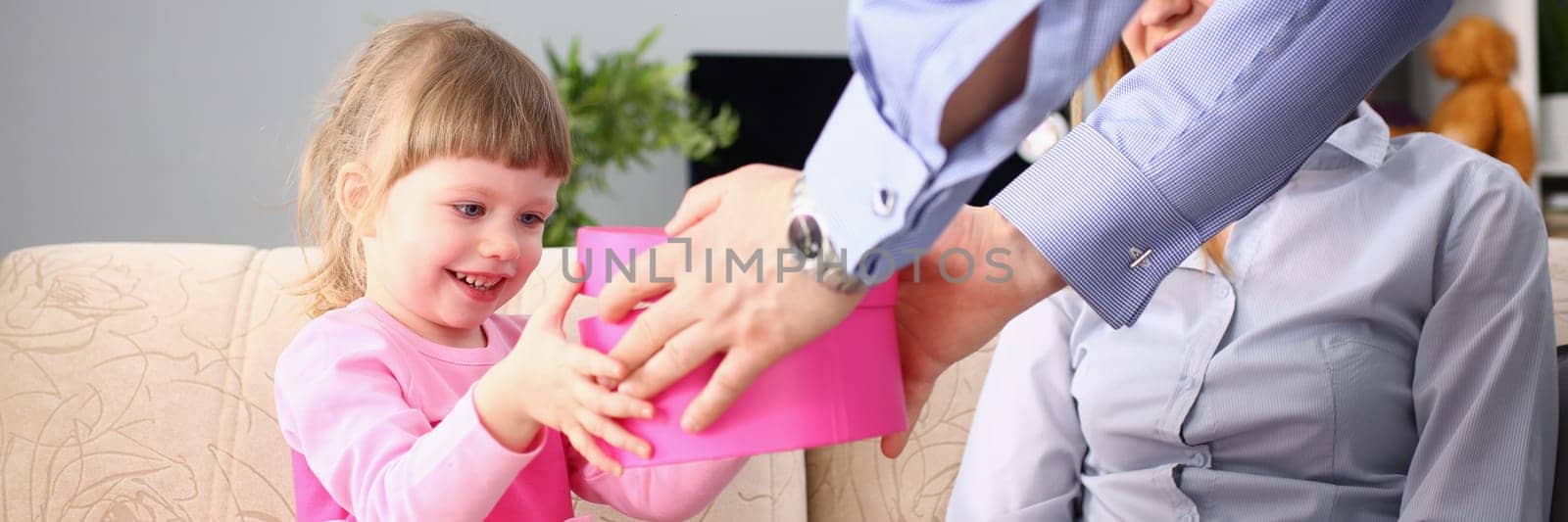 Parents give little girl child gift box. Surprise birthday and gift for daughter