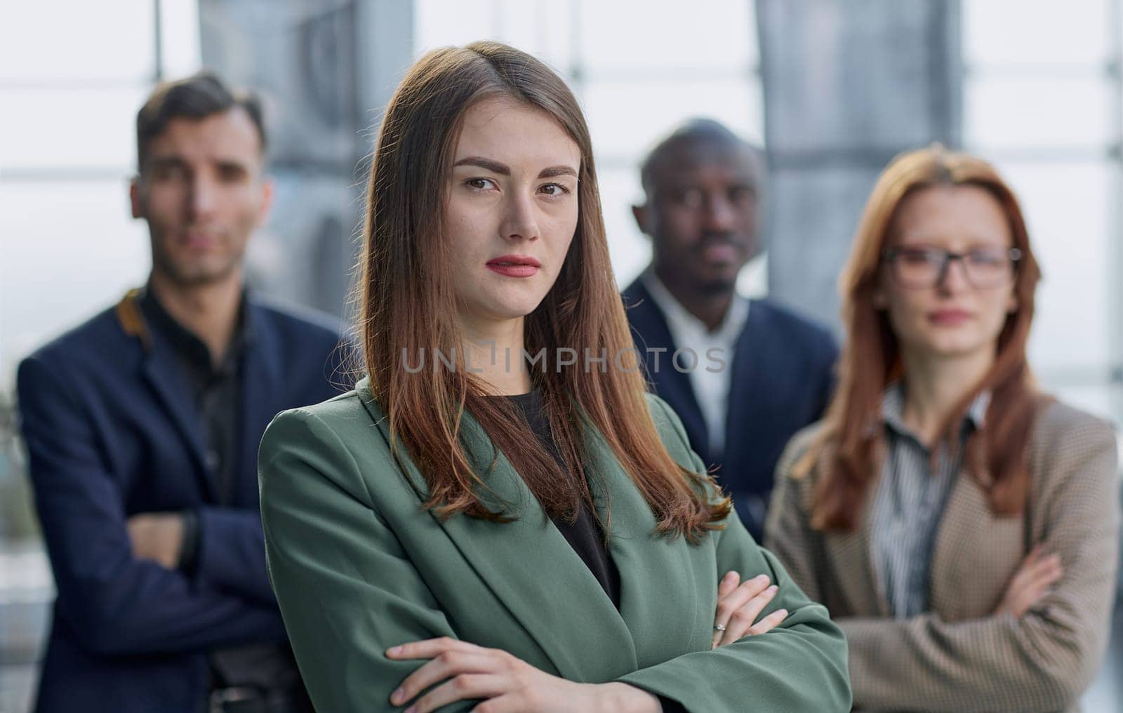 Portrait of a young serious business woman with colleagues by Prosto
