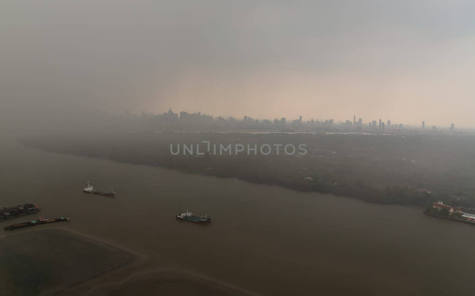 Bangkok, Thailand - May 28, 2023 - Misty Landscape of city skyscrapers covered before raining. Heavy dense smog fot during afternoon that Bangkok city cannot be seen clearly, Aerial top view of city on a foggy day, Space for text, No focus, specifically.