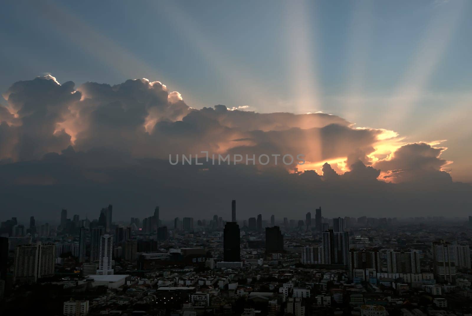 Divine glow through the Clouds of the Morning or Evening warm Sun over Large Metropolitan city with Skyscrapers on Background. The Stunning Beauty of a Sunrise or Sunset, They can be used as Wallpaper that look Amazing, Space for text, Selective focus.