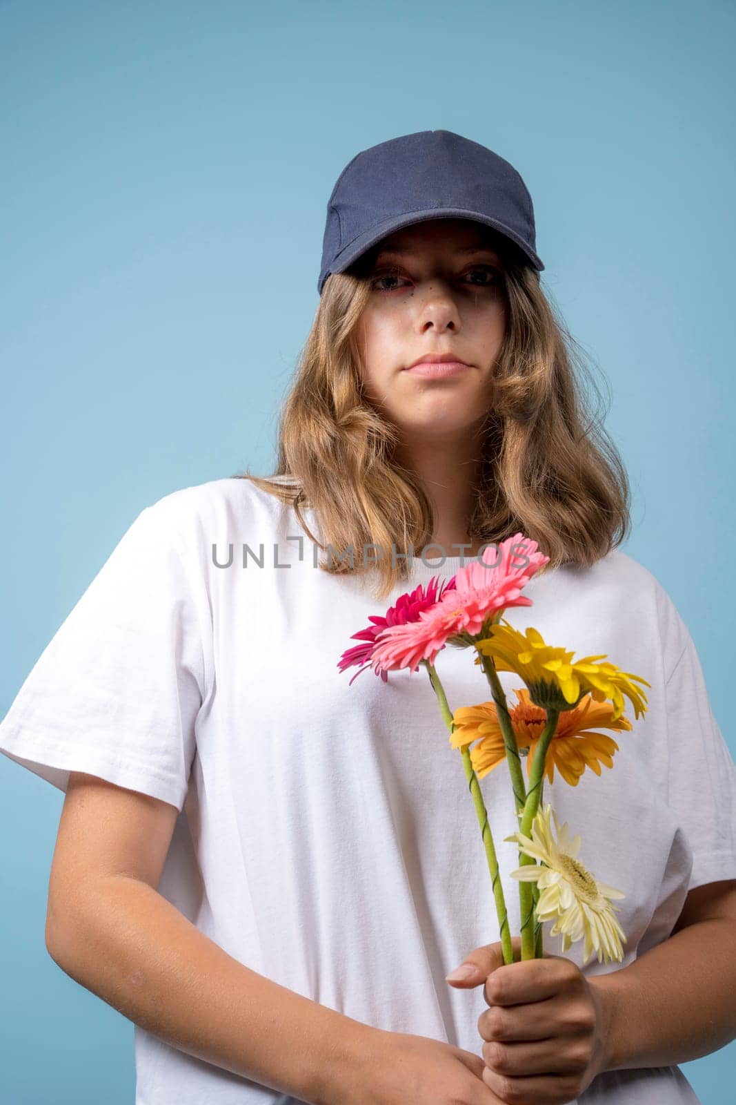 portrait of a pretty Caucasian girl with gerbera flowers on a blue background by audiznam2609