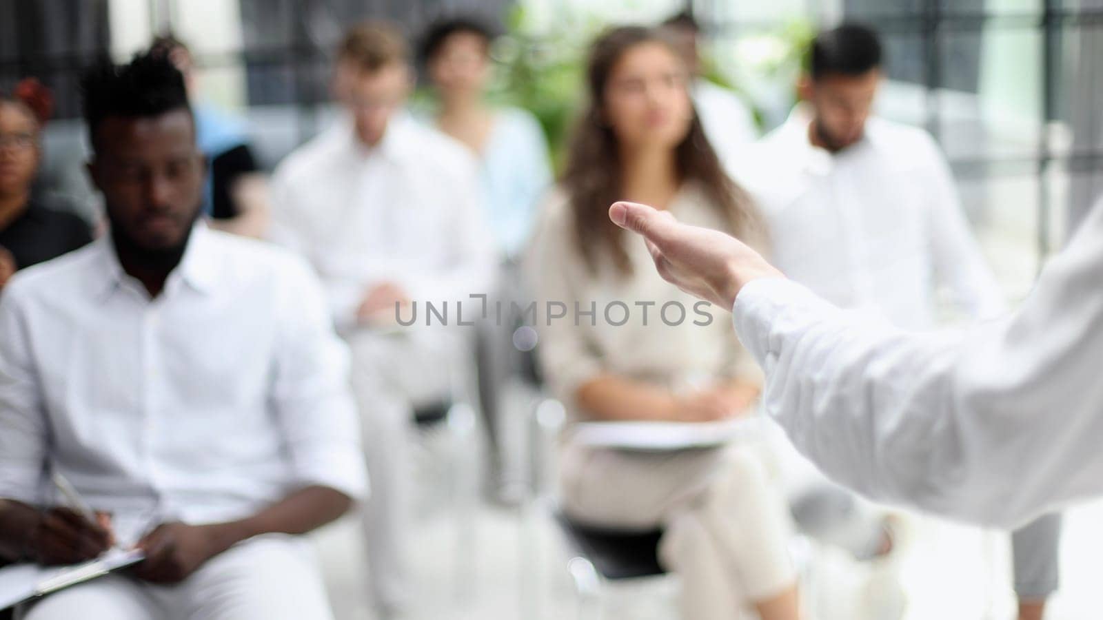 Selective focus of young businesswoman together with interracial colleagues during seminar