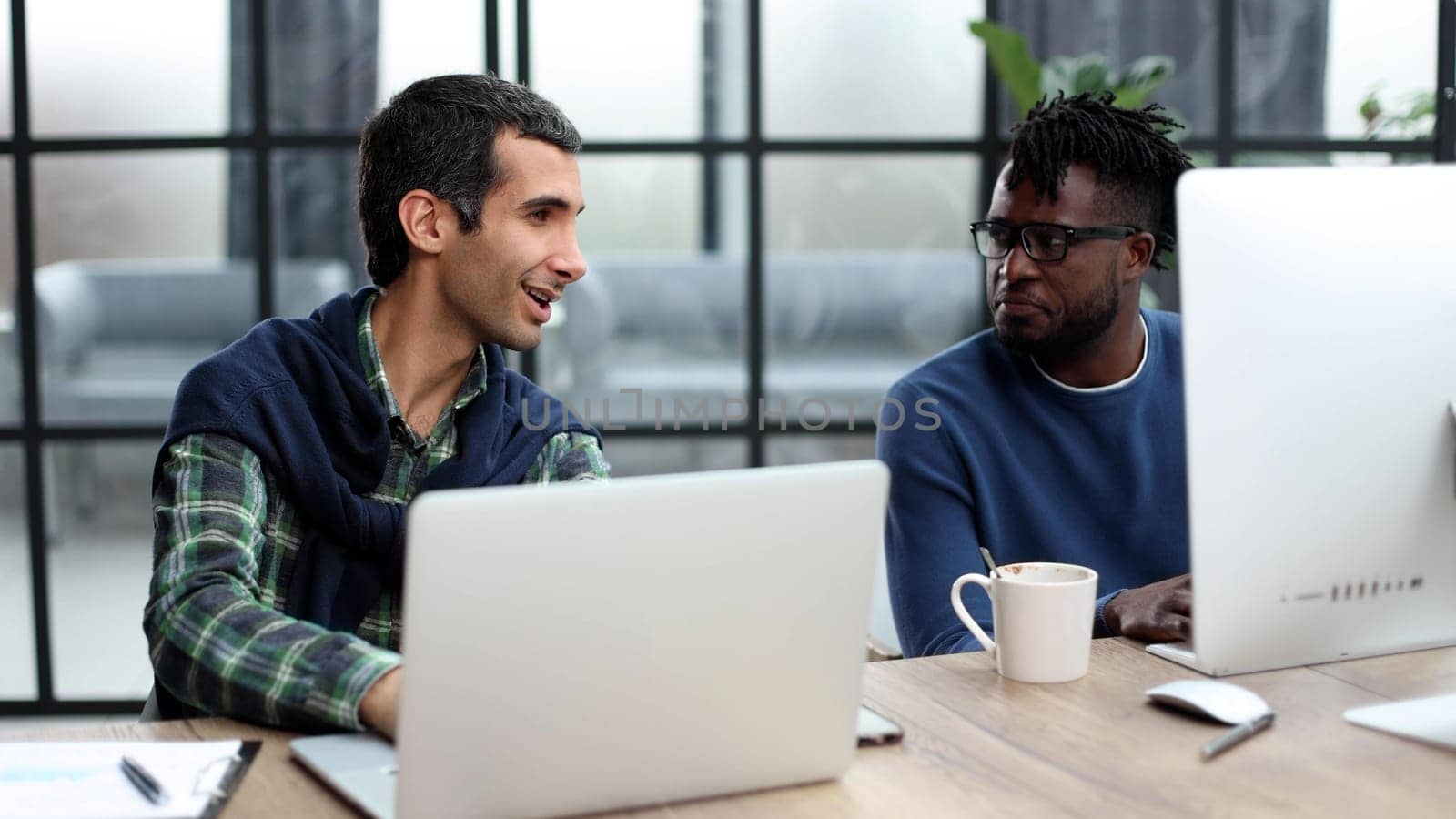 Smiling beautiful businesspeople working on laptop in modern office lobby