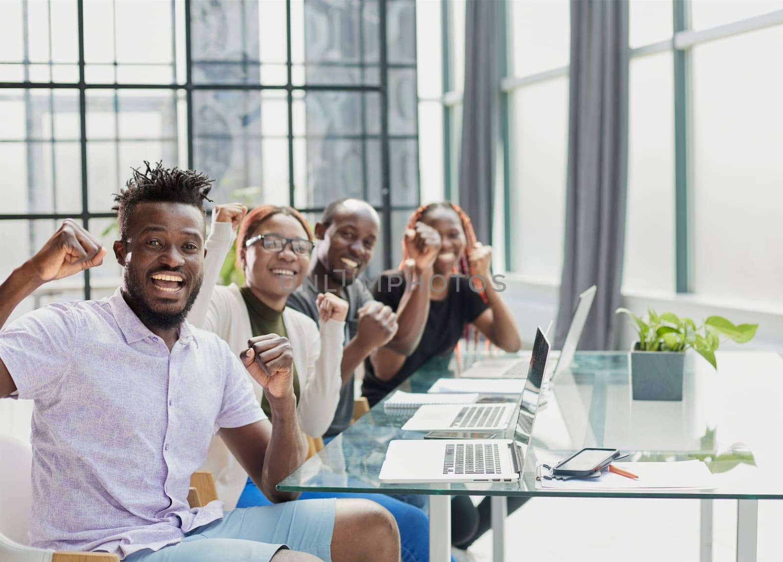 Happy young African-American man and his team in background