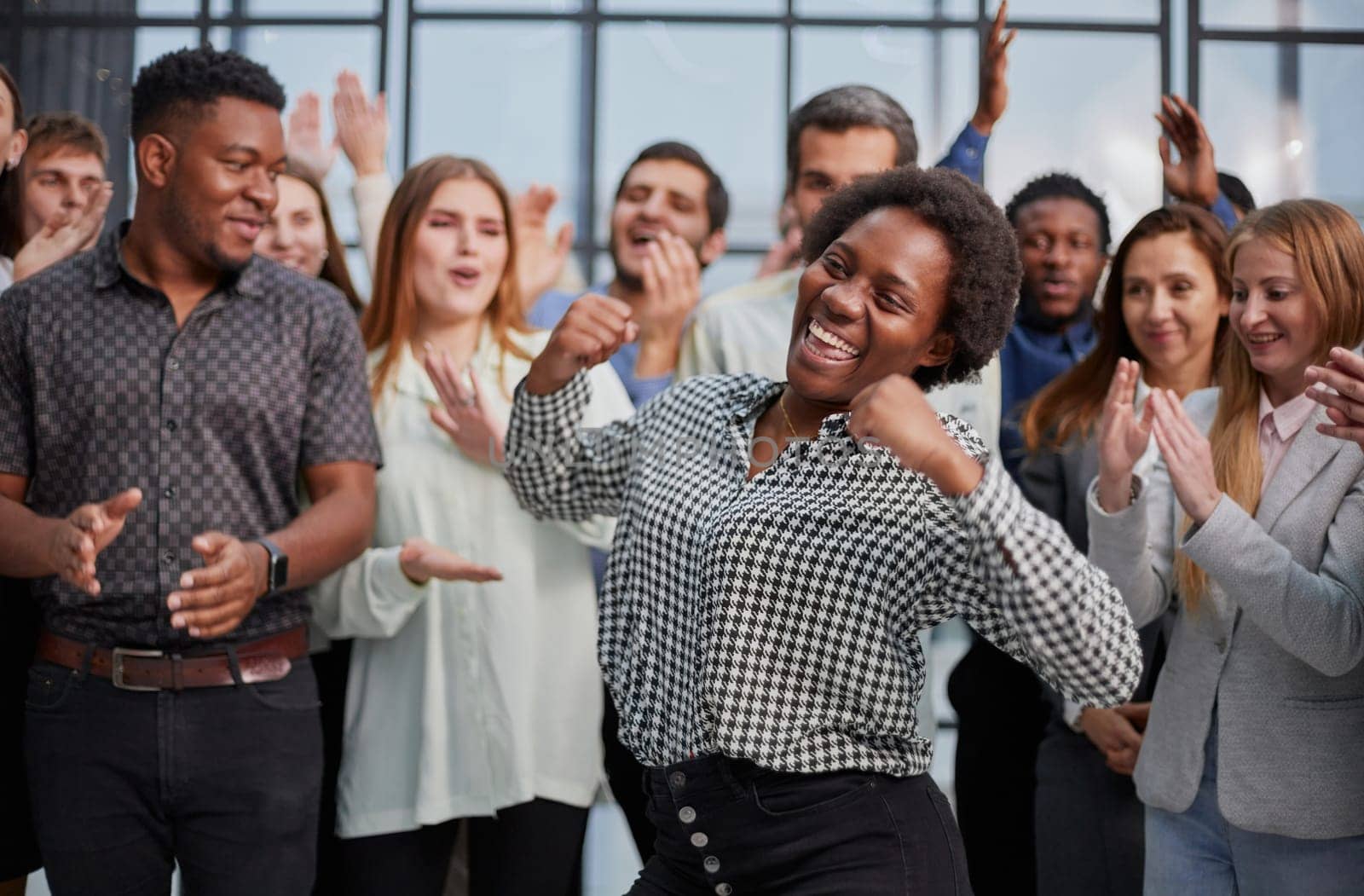 Smiling multiethnic colleagues celebrating common business success or victory in the office.