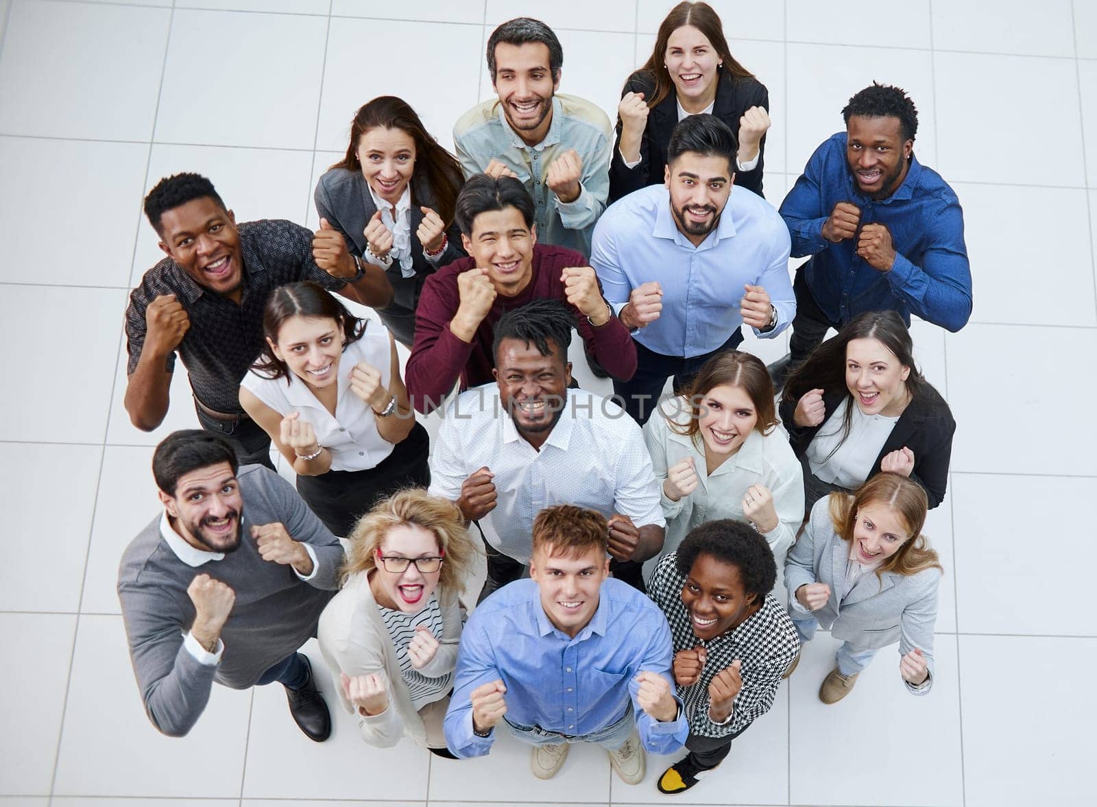 large group of young people looking up with clenched fists celebrating victory