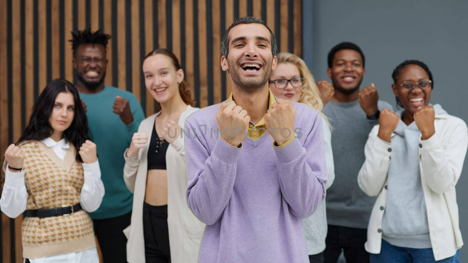 Happy people raise their hands up clenching their fists. Success concept