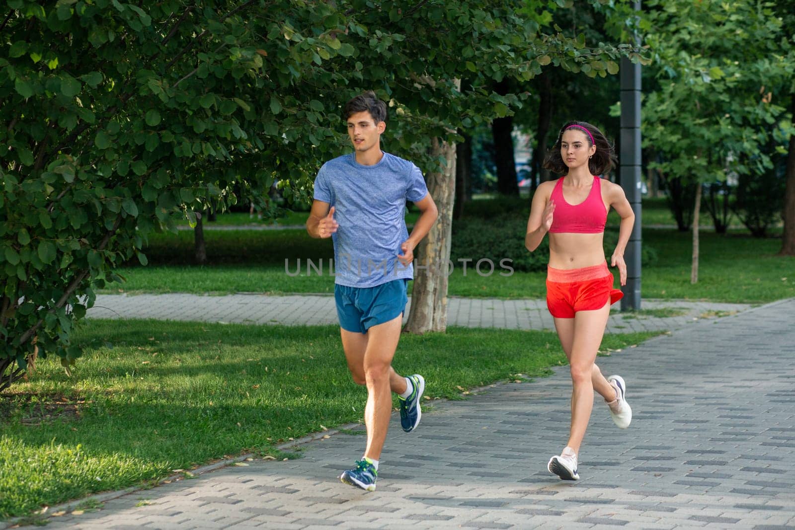 Portrait of cheerful caucasian couple running outdoors by nazarovsergey