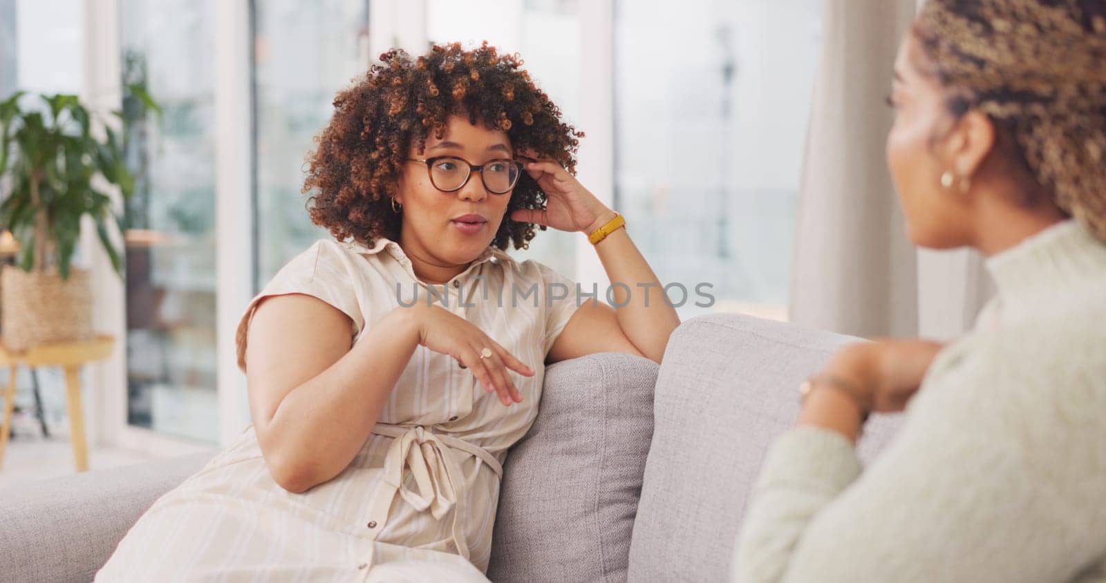 Talking, bonding and friends sharing a story, secret or gossip on the sofa together. Happy, relax and women on the living room couch for advice, communication and catching up conversation at home.