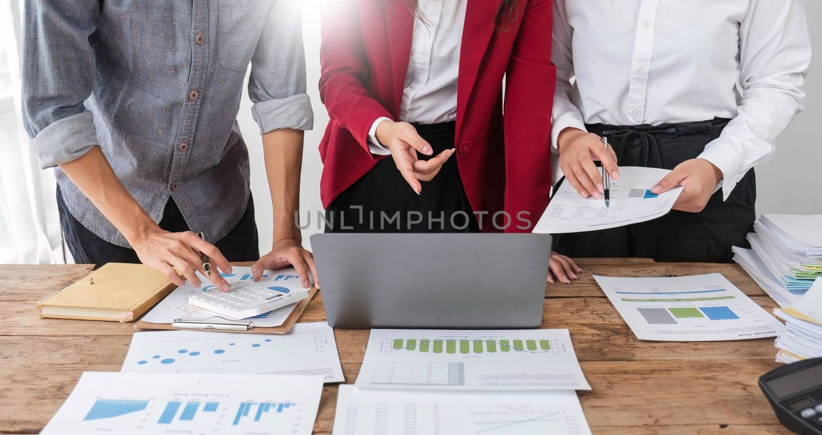 Business People Meeting using laptop computer,calculator,notebook,stock market chart paper for analysis Plans to improve quality next month. Conference Discussion Corporate Concept