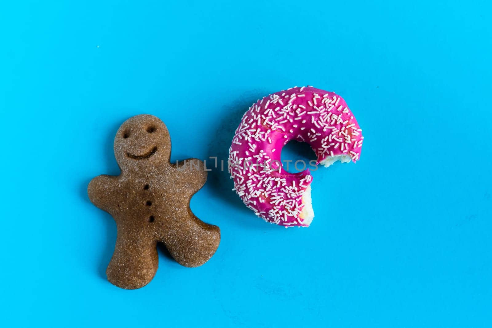 Donut with hazelnuts on blue background, close up by Zelenin