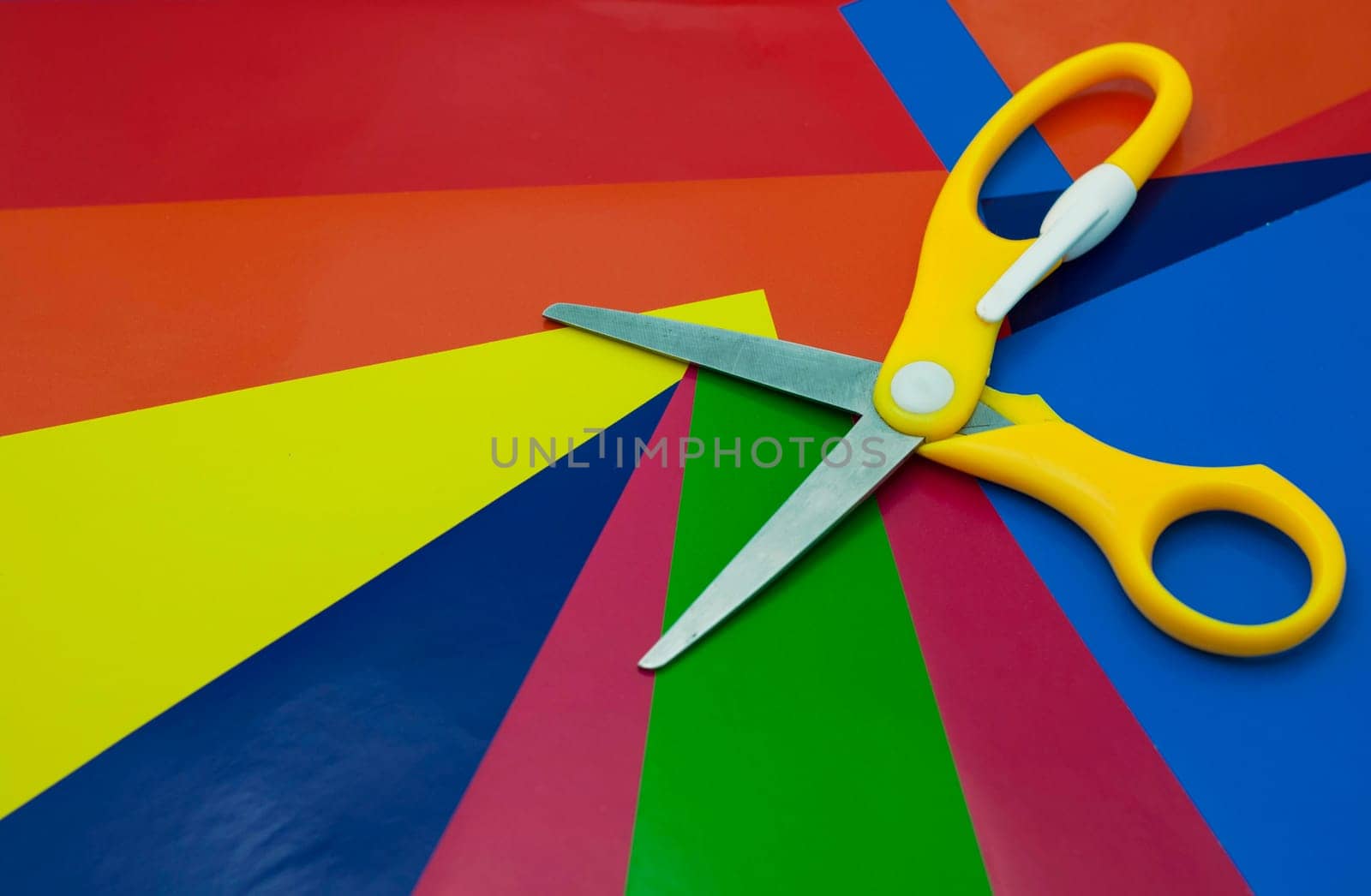 colorful paper background. Sheets of colored paper, iridescent palette of colored paper, rainbow colors. Top view table with colored paper and scissors. by aprilphoto