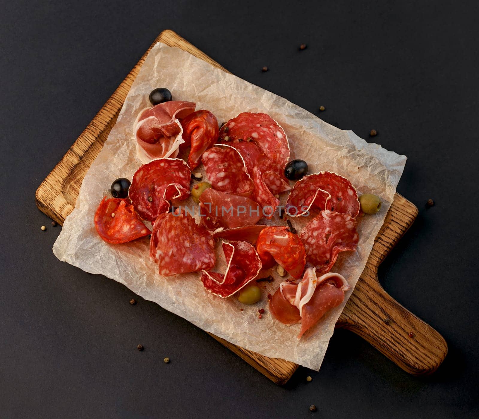 Meat Charcuterie Plate with Prosciutto crudo, Salami and Coppa Sausage. Black background. Top view. by aprilphoto
