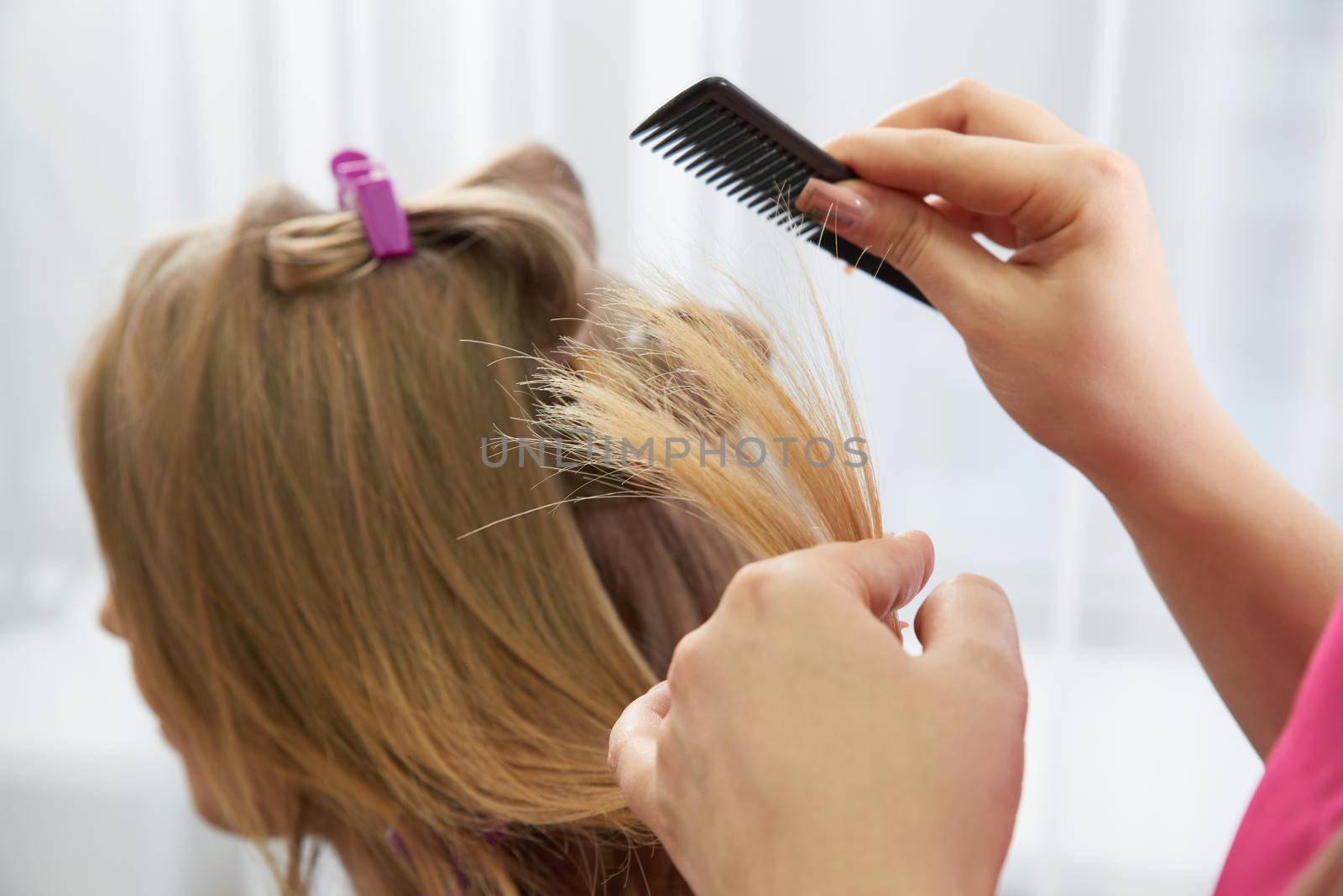 Hairdresser styling hair of a client in a beauty salon