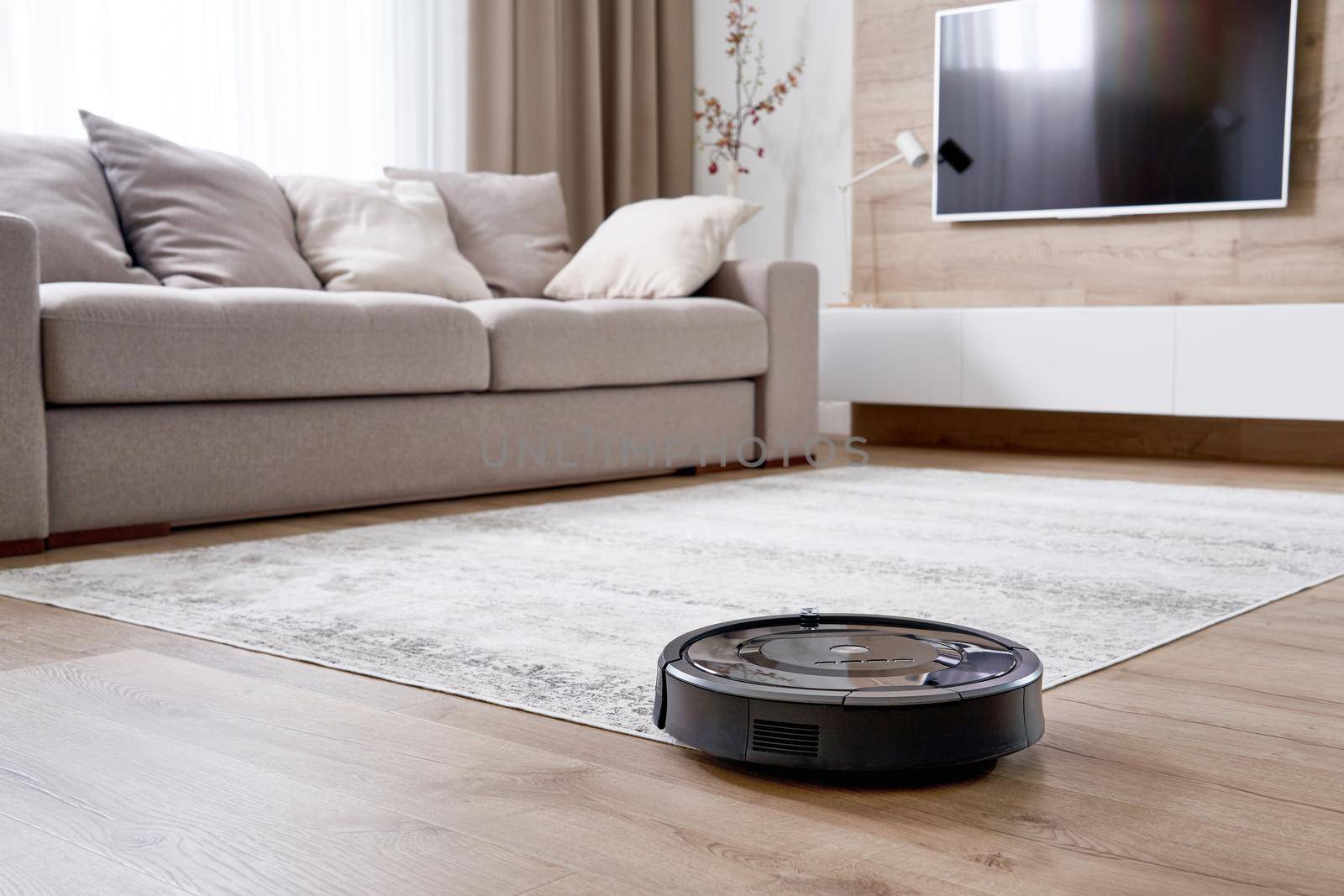 Robotic vacuum cleaner on carpet in cozy living room