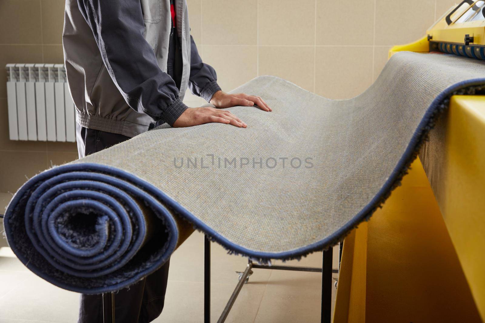 Man worker cleaning carpet on automatic washing machine equipment and dryer in the Laundry room