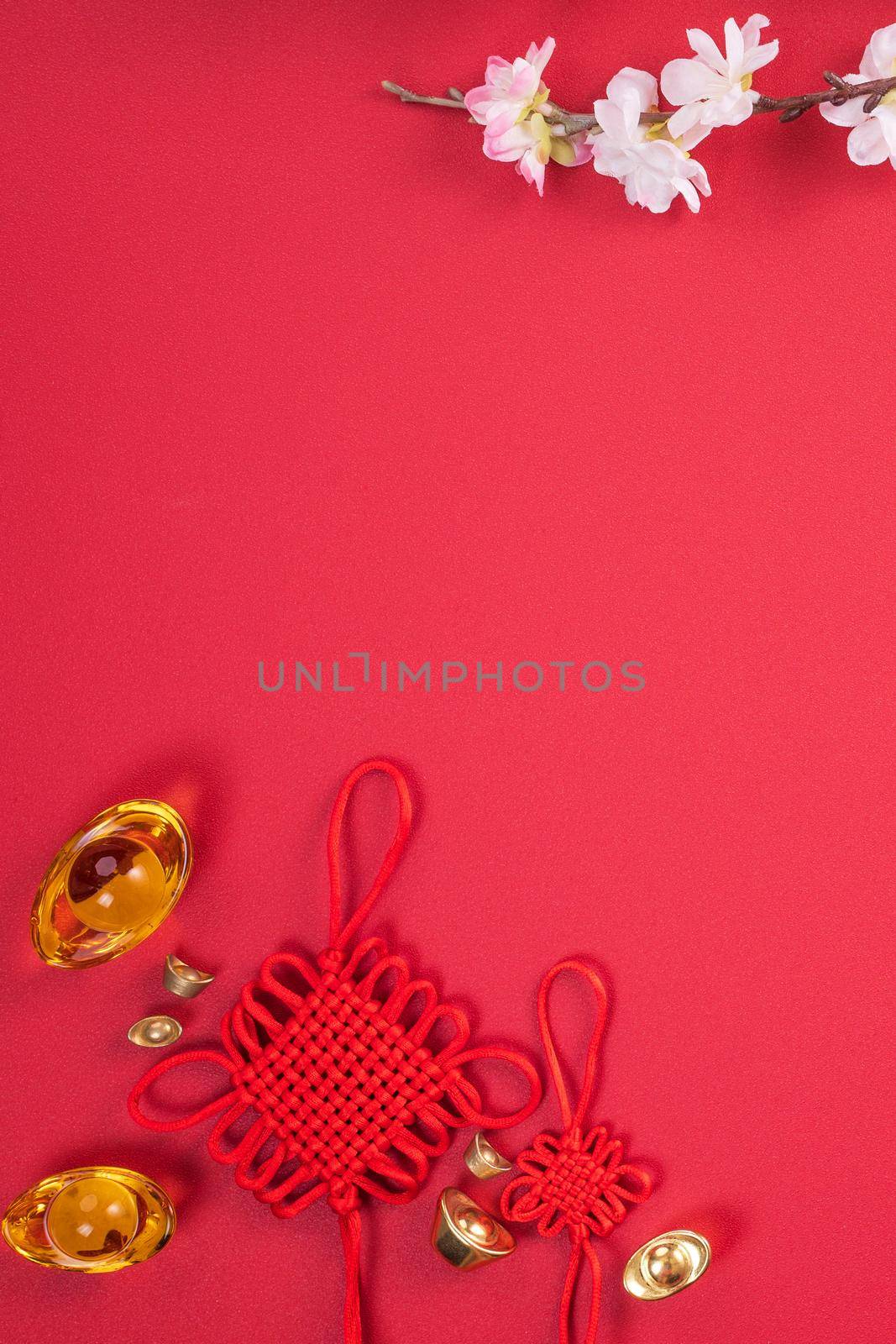 Design concept of Chinese lunar new year - Beautiful Chinese knot with plum blossom isolated on red background, flat lay, top view, overhead layout. by ROMIXIMAGE