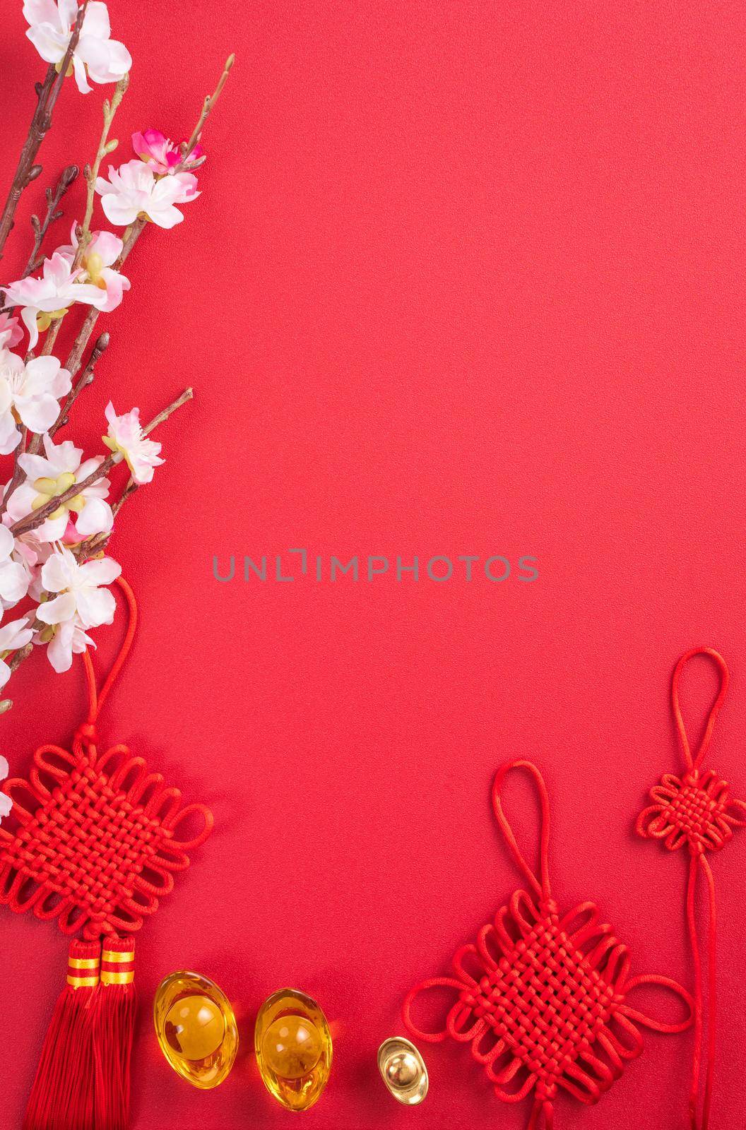 Design concept of Chinese lunar new year - Beautiful Chinese knot with plum blossom isolated on red background, flat lay, top view, overhead layout. by ROMIXIMAGE